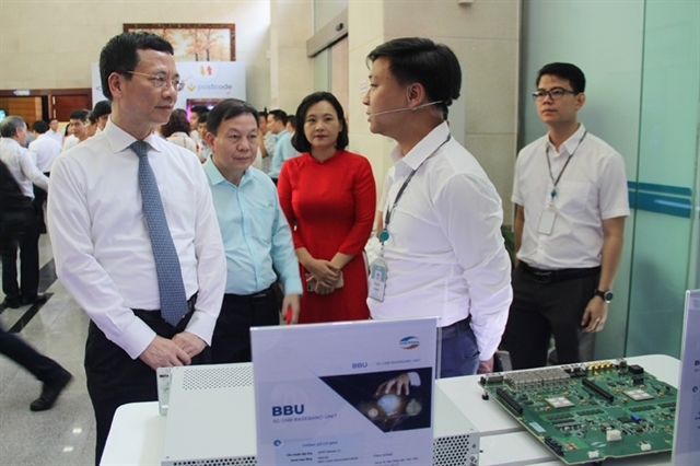 Minister of Information and Communications Nguyễn Mạnh Hùng (left) looks at digital technologies on display. — File Photo
