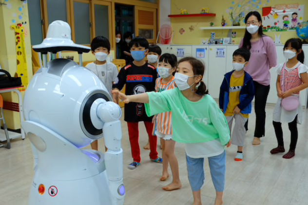 Students practice dance moves with a robot at Wooam Elementary School in Seoul. MUST CREDIT: Washington Post photo by Min Joo Kim