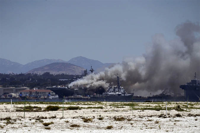 Smoke rises from a fire aboard the USS Bonhomme Richard at Naval Base San Diego on Sunday. (Bing Guan/Reuters)