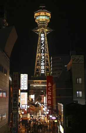 Tsutenkaku tower in Naniwa Ward, Osaka, is illuminated in yellow on Sunday evening. (The Yomiuri Shimbun)