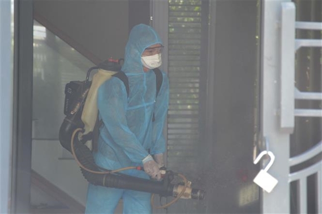 Health officials spray disinfectant around the home of the latest COVID-19 patient in Liên Chiểu District, Đà Nẵng City on July 24. — VNA/VNS Photo