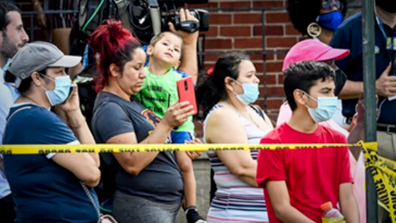 Neighbors watch first responders after an explosion destroyed three homes and killed a person in Baltimore on Monday, Aug. 10, 2020. MUST CREDIT: Washington Post photo by Bill O'Leary
