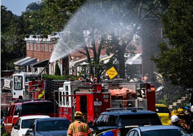 Fire engines pour water onto the rubble after an explosion destroyed three homes and killed two people in Baltimore on Monday, Aug. 10, 2020. CREDIT: Washington Post photo by Bill O'Leary