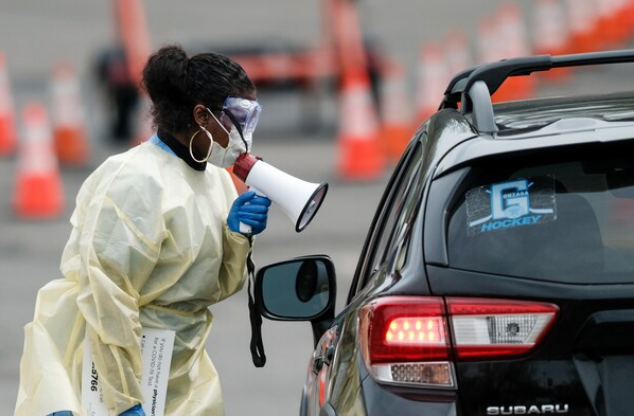 A medical worker in March instructs a driver at a coronavirus testing site in Arlington, Va. MUST CREDIT: Photo for The Washington Post by Michael A. McCoy