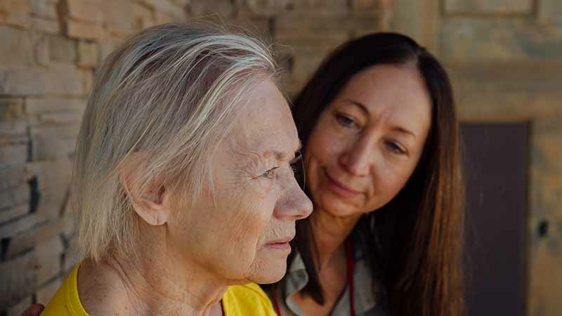 Dena Ducane and her mother, Rhoda Dobrovich, spend time on Dena's front porch last month in Santa Fe. MUST CREDIT: Photo by Mary Mathis for The Washington Post.