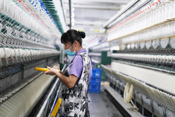 A woman works at the workshop of a textile company in Qinggang county, Northeast China's Heilongjiang province, April 16, 2020. [Photo/Xinhua]