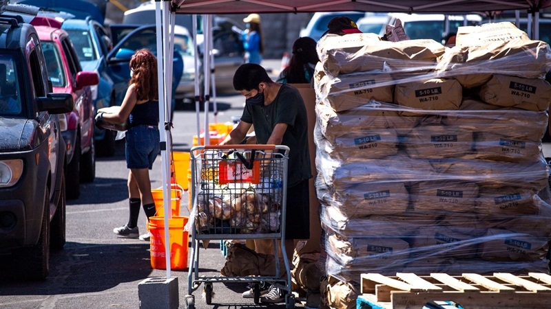 A Kelly Center for Hunger Relief volunteer sorts through food for distribution as residents in vehicles wait in line at a church in El Paso, Texas, on July, 17, 2020. MUST CREDIT: Bloomberg photo by Joel Angel Juarez.