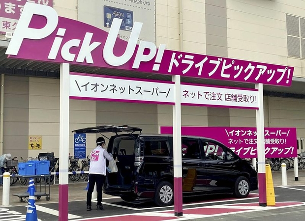 An Aeon employee loads items into a customer’s vehicle at a Drive Pickup! corner in a parking lot of the Aeon Higashi-Kurume store in Tokyo on Thursday. (The Yomiuri Shimbun)