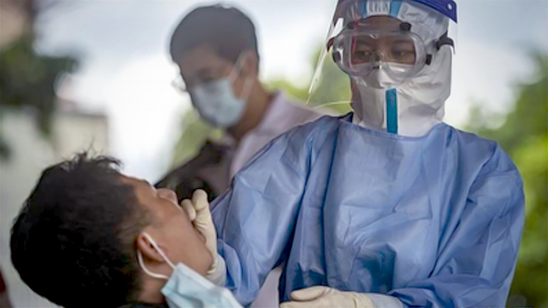 A medical worker collects a swab sample to test for COVID-19 at a community nucleic acid testing site in Ruili, Yunnan province on Sept 15, 2020. [Photo/Xinhua]