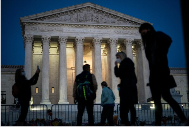 The sun sets as people gather to pay respects to Justice Ruth Bader Ginsburg in front of the Supreme Court on Monday, Sept 21, 2020. MUST CREDIT: Washington Post photo by Jabin Botsford