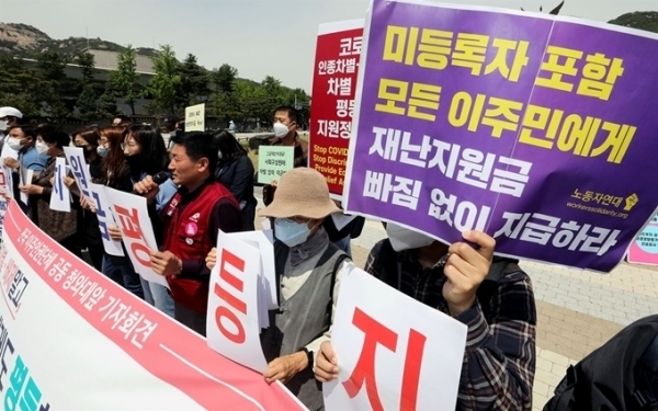 Activists demand that the government pay emergency relief funds to foreigners living here as well, at a press conference in Seoul in May. (Yonhap)