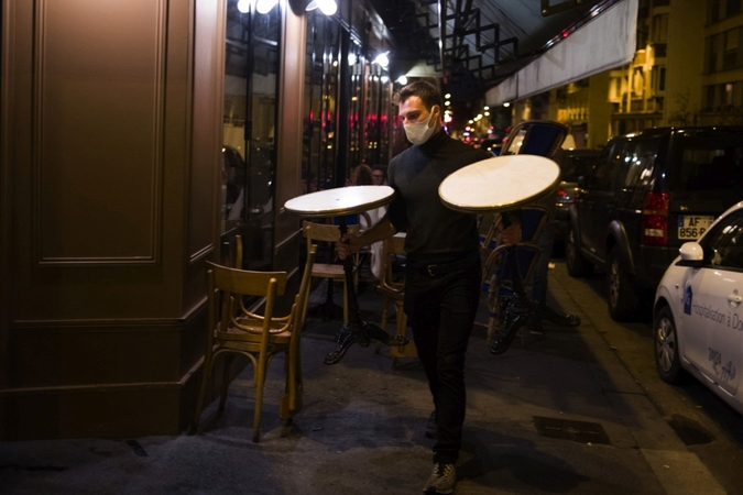 A waiter wearing a protective face mask carries terrace tables during closing time in Paris on Sept. 28, 2020. MUST CREDIT: Bloomberg photo by Nathan Laine.
/Photo by: Nathan Laine — Bloomberg
Location: Paris, France