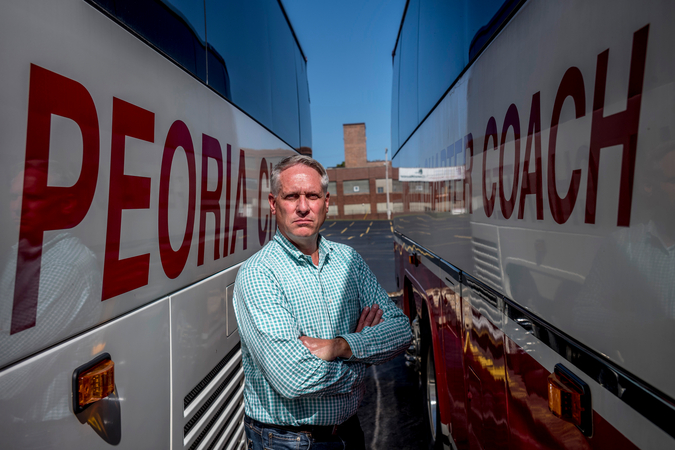 Bill Winkler, president and owner of Peoria Charters, stands next to buses in his company parking lot in Peoria, Ill., on Wednesday, Oct. 7, 2020. MUST CREDIT: Photo for The Washington Post by David Zalaznik