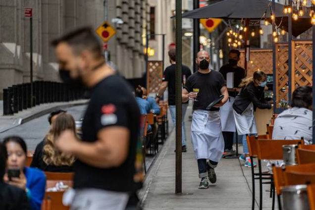 Waiters assist diners at a restaurant in New York on Sept. 26, 2020. MUST CREDIT: Bloomberg photo by David Dee Delgado.