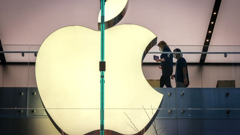 Employees wear protective masks as they walk past signage displayed in the window of the Apple Inc. flagship store in Sydney on Sept. 18, 2020. MUST CREDIT: Bloomberg photo by David Gray.