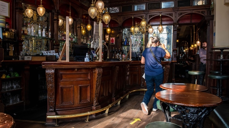 A customer walks through the bar area at St Stephen's Tavern pub in London on Sept. 22, 2020. MUST CREDIT: Bloomberg photo by Chris J. Ratcliffe.