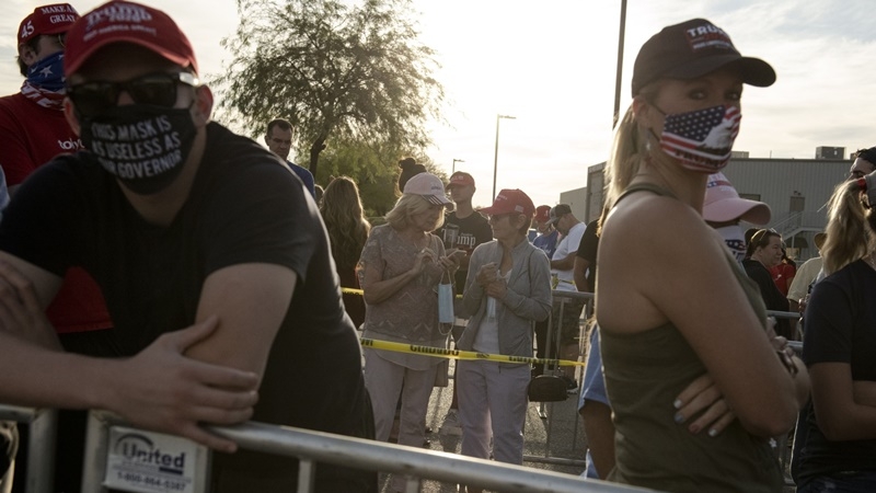 Attendees wear protective masks while waiting in line before a campaign rally with Vice President Mike Pence in Boulder City, Nev., on Oct. 8, 2020. MUST CREDIT: Bloomberg photo by Bridget Bennett.