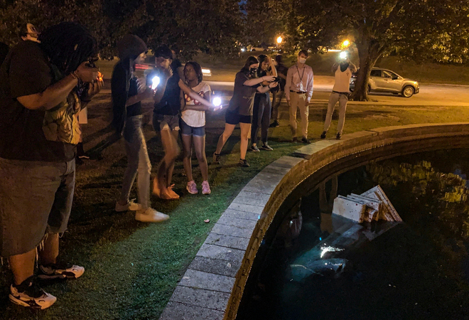 A statue of Christopher Columbus is dumped into a lake in Richmond, Va. MUST CREDIT: Washington Post photo by John McDonnell