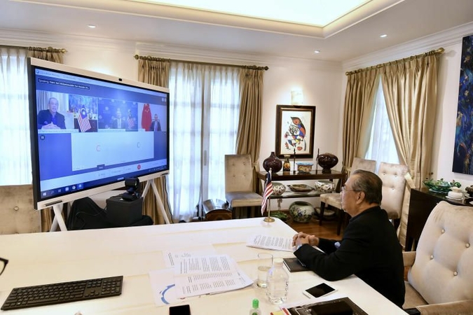 Malaysian Prime Minister Tan Sri Muhyiddin Yassin holding a live video conference with Chinese Foreign Minister Wang Yi (screen display, right) and Foreign Minister Datuk Seri Hishammuddin Tun Hussein (screen display, centre) at his residence on Tuesday (Oct 13). - Bernama