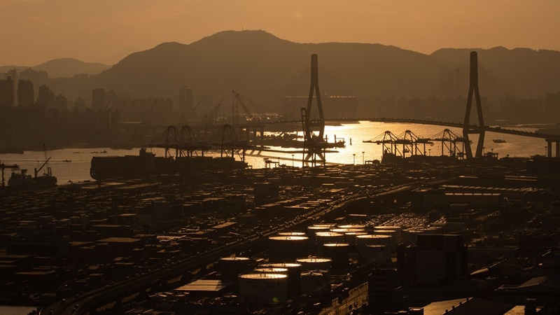 Vehicles drive through the road as shipping containers sit at the Busan Port Terminal, left, and oil tankers stand in Busan, South Korea, on Oct. 13, 2020. MUST CREDIT: Bloomberg photo by SeongJoon Cho.