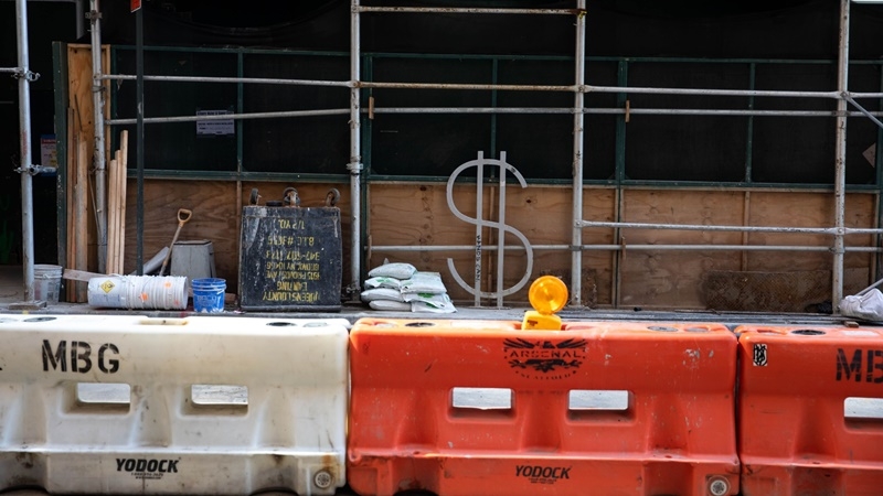 A dollar sign bike rack, designed by David Byrne, stands surrounded by scaffolding and construction material along Wall Street in New York on July 20, 2020. MUST CREDIT: Bloomberg photo by Michael Nagle.