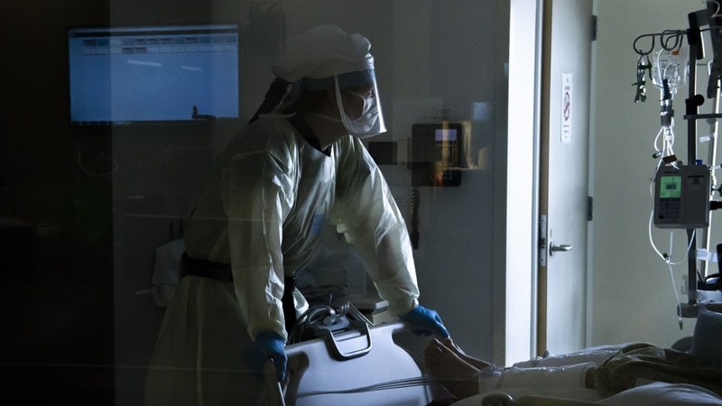 Registered Nurse Keegan Williamson-Hayes watches a patients vital signs while wearing a powered air-purifying respirator (PAPR) inside the covid-19 intensive care unit at PeaceHealth Southwest Medical Center in Vancouver, Wash., on April 30, 2020. MUST CREDIT: Bloomberg photo by Nathan Howard.