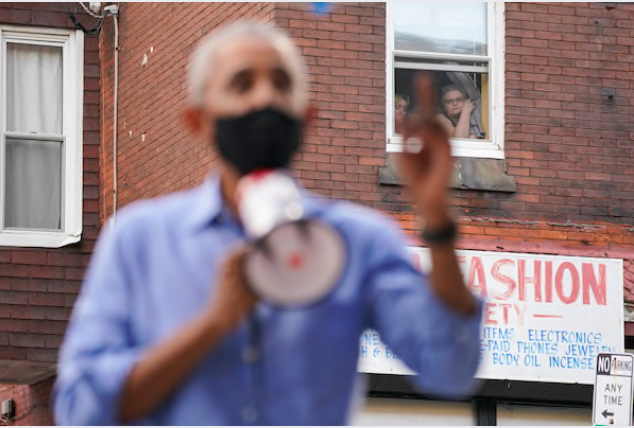 Women watch from a window as former president Barack Obama campaigns in Philadelphia on Wednesday for Democratic nominee Joe Biden. MUST CREDIT: Washington Post photo by Bonnie Jo Mount