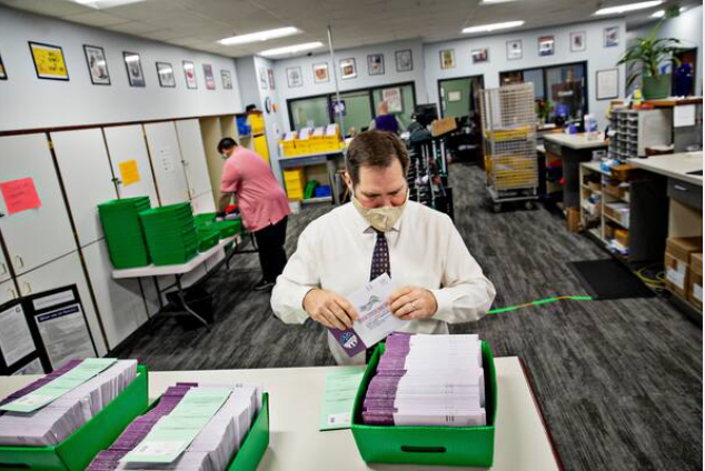 Weber County Clerk/Auditor Ricky Hatch helps organize mail-in ballots at the Weber County Clerk's Office in Ogden, Utah, on Oct. 23, 2020. MUST CREDIT: Photo for The Washington Post by Kim Raff