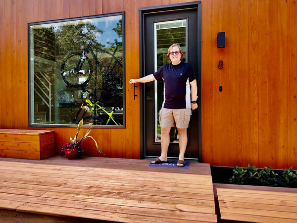 Tim Mastic in front of his tiny house in the Escape Tampa Bay Village community in Florida. MUST CREDIT: David Peterson.