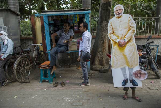 A boy carries a cardboard cut-out of India Prime Minister Narendra Modi after a Bharatiya Janata Party election rally in Gaya, Bihar, India, on Oct. 23, 2020. MUST CREDIT: Bloomberg photo by Prashanth Vishwanathan.
