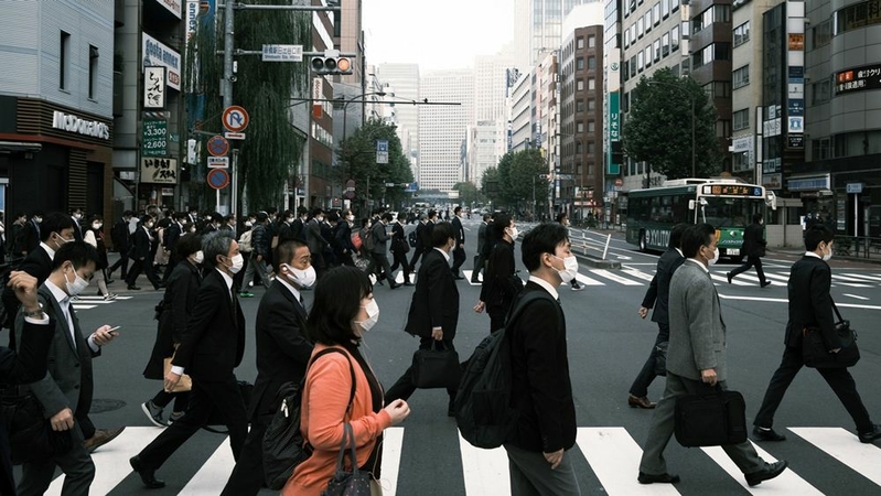 Pedestrians wearing protective masks cross a road in Tokyo on Nov. 19, 2020. MUST CREDIT: Bloomberg photo by Soichiro Koriyama.