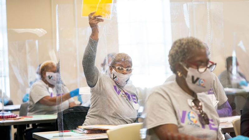 A Clayton County election worker holds up a sign signaling she needs help with determining a vote during a hand recount for the presidential election in Georgia last week. The state is the first of those where President Trump has mounted legal challenges to certify its results, confirming a 12,284-vote lead for former vice president Joe Biden. MUST CREDIT: Photo by Kevin D. Liles for The Washington Post