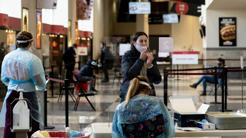 Maggie Pidto, 21, a senior at the University of Wisconsin at Madison, swabs inside her nose to test for the coronavirus at the Kohl Center arena, an on-campus testing site. MUST CREDIT: Photo for The Washington Post by Lauren Justice