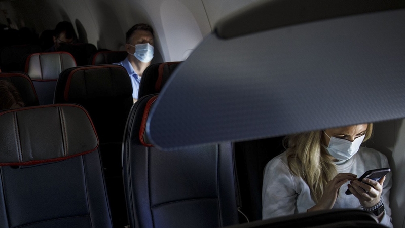Passengers wear protective masks on an American Airlines flight departing from Los Angeles International Airport on June 13, 2020. MUST CREDIT: Bloomberg photo by Patrick T. Fallon