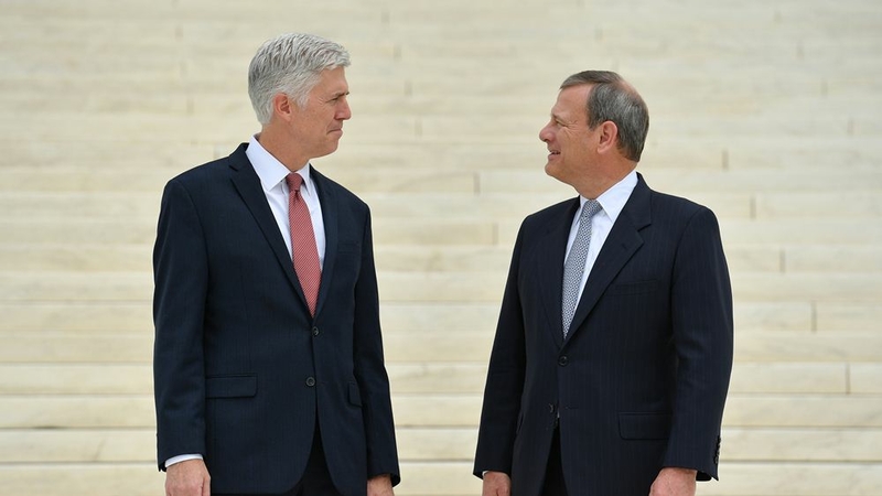 Justice Neil Gorsuch, left, is accompanied by Chief Justice John Roberts Jr. following his investiture ceremony at the Supreme Court in June 2017. MUST CREDIT: Washington Post photo by Ricky Carioti