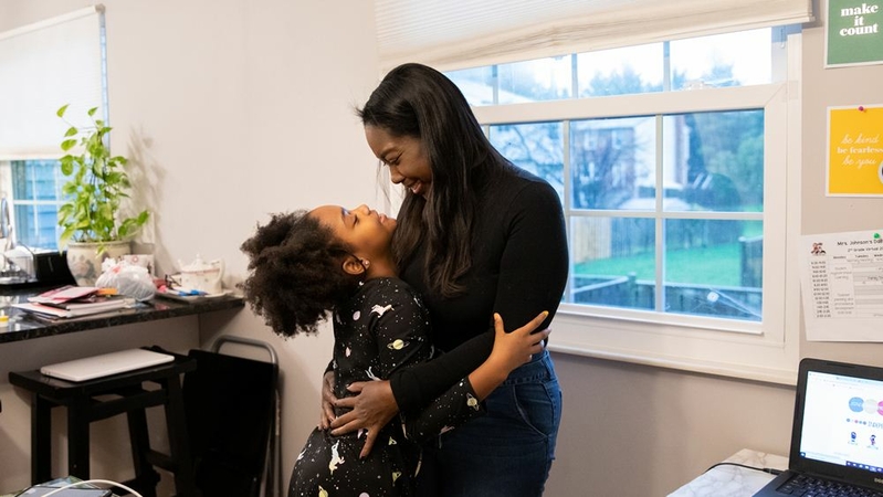 Karen James embraces her daughter Olivia James, 7, during a break from school and work at their home in Alexandria, Va. MUST CREDIT: Photo for The Washington Post by Amanda Andrade-Rhoades
