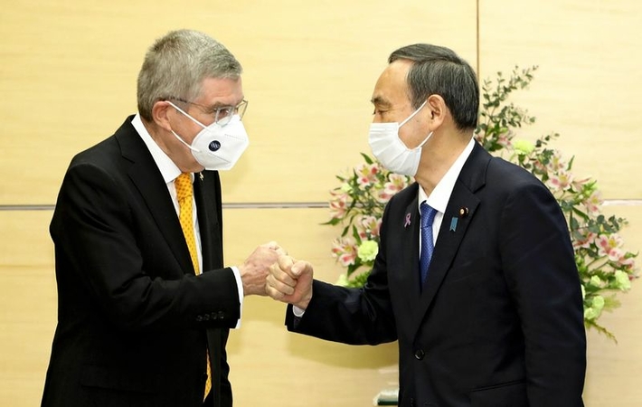 International Olympic Committee President Thomas Bach, left, and Prime Minister Yoshihide Suga bump fists at the Prime Minister’s Office in Tokyo on Nov. 16. (The Yomiuri Shimbun)