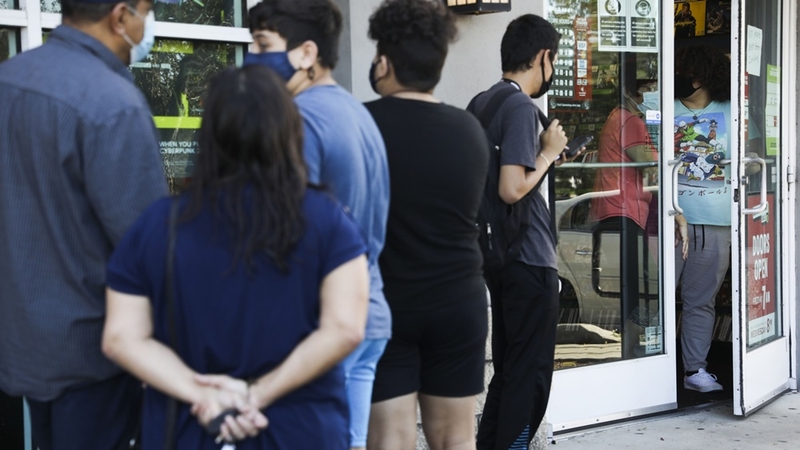 People stand in line to enter a GameStop store in Tampa, Florida, on Nov. 27. MUST CREDIT: Bloomberg photo by Eve Edelheit.