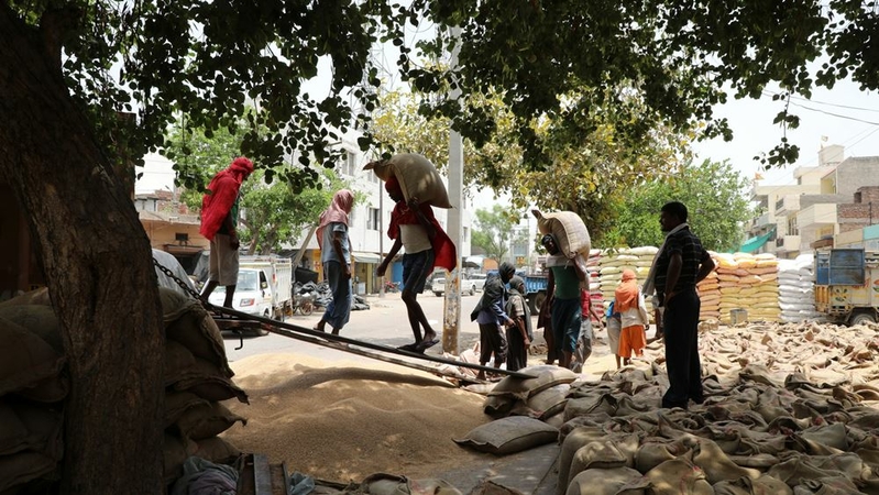 Workers load sacks of wheat grain onto a truck at a wholesale grain market in Rewari, India, on May 8, 2019. MUST CREDIT: Bloomberg photo by T Narayan.