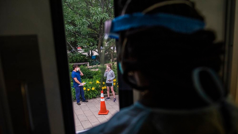 A nurse looks out the window before starting to take patients for covid-19 antibody testing at a testing site in the summer in the Navy Yard neighborhood. MUST CREDIT: photo for The Washington Post by Amanda Voisard.