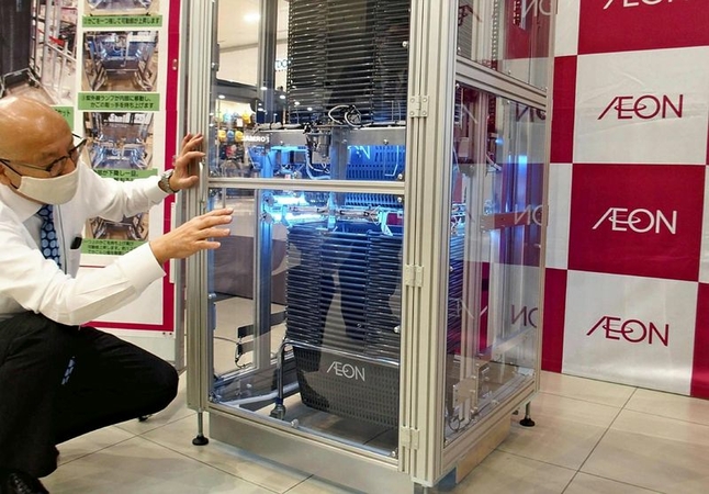 An Aeon Retail Co. official shows an automated shopping basket sanitizer. (The Yomiuri Shimbun)