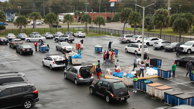 Dozens of vehicles wait to receive food at the Seasons Florida Resort in Kissimmee on Saturday, part of a food drive for Disney cast members and other tourism workers who have been furloughed or laid off. MUST CREDIT: Photo by Eve Edelheit for The Washington Post.
