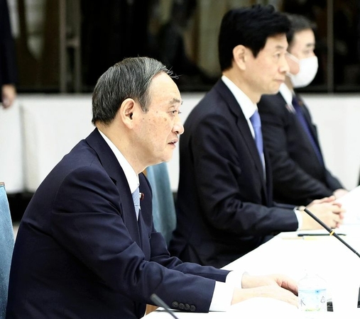 Prime Minister Yoshihide Suga attends a meeting of the government’s Council on Economic and Fiscal Policy at the Prime Minister’s Office on Tuesday. Economic Revitalization Minister Yasutoshi Nishimura is seated next to him. (The Yomiuri Shimbun)