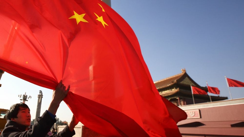 A worker lowers a Chinese national flag in front of Tiananmen Gate in Beijing on Nov. 9, 2014. MUST CREDIT: Bloomberg photo by Tomohiro Ohsumi.