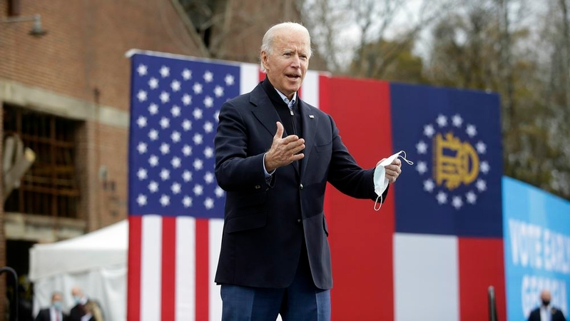 President-elect Joe Biden acknowledges the crowd Tuesday as he attends a rally with Democratic Senate nominees Raphael Warnock and Jon Ossoff in Atlanta. MUST CREDIT: Washington Post photo by Joshua Lott.