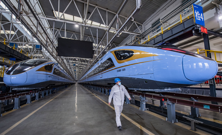 Two new models of the Fuxing high-speed train are parked at China State Railway Group Co's branch in Xi'an, Shaanxi province, on Tuesday. The trains will operate on the Yinchuan-Xi'an High-Speed Railway, which is scheduled to open on Dec 26. [Photo by Yuan Jingzhi/For China Daily]