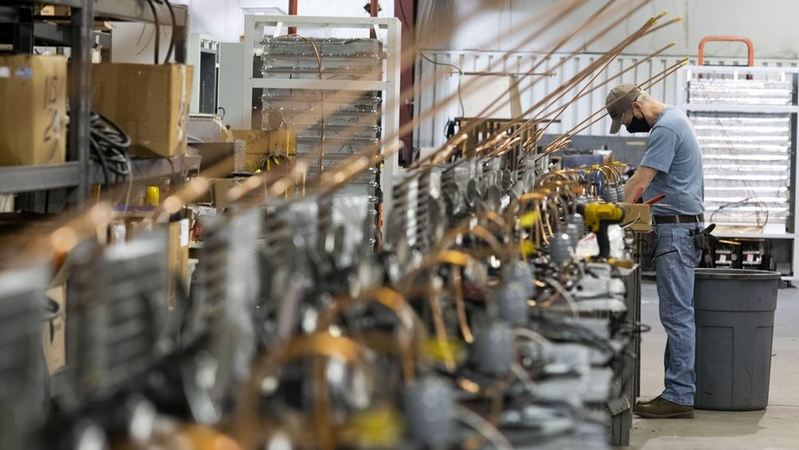 An employee wearing a protective mask assembles oil separators and condensers for ultra low temperature (ULT) freezers at the So-Low Environmental Equipment Co. manufacturing facility in Cincinnati on Dec. 9, 2020. MUST CREDIT: Bloomberg photo by Ty Wright.