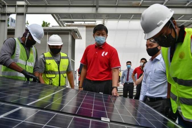 NTUC's Secretary-General Ng Chee Meng (centre) observes workers as they install a solar panel during the Career Development Plan for the Solar Industry event on Dec 17, 2020. ST PHOTO: CHONG JUN LIANG