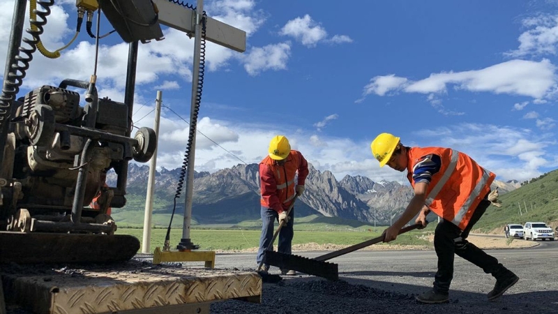 China Railway employees pave a road in Batang county, Sichuan province, in July. [Photo provided to China Daily]