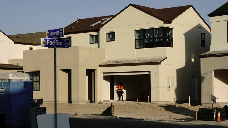 A worker stands inside the garage of a new home under construction by Pardee Construction in the Pacific Highlands Ranch master planned community in San Diego on Aug. 31, 2020. MUST CREDIT: Bloomberg photo by Bing Guan.